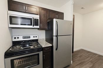 Photo of a stainless steel microwave, electric oven, and refrigerator  at Bennett Ridge Apartments, Oklahoma City
